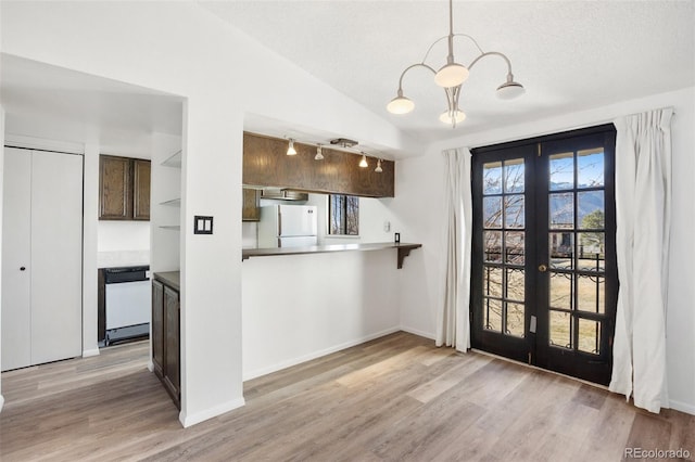 kitchen with french doors, white refrigerator, vaulted ceiling, dishwashing machine, and dark brown cabinets