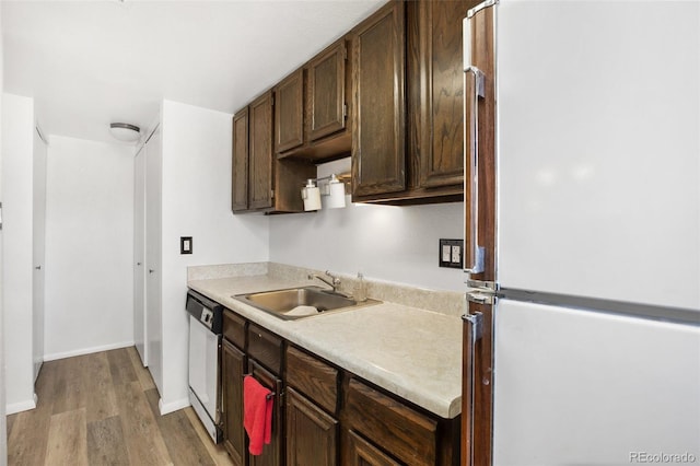 kitchen featuring refrigerator, sink, light wood-type flooring, dishwashing machine, and dark brown cabinets