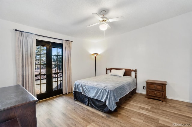 bedroom with ceiling fan, french doors, a textured ceiling, access to outside, and hardwood / wood-style flooring