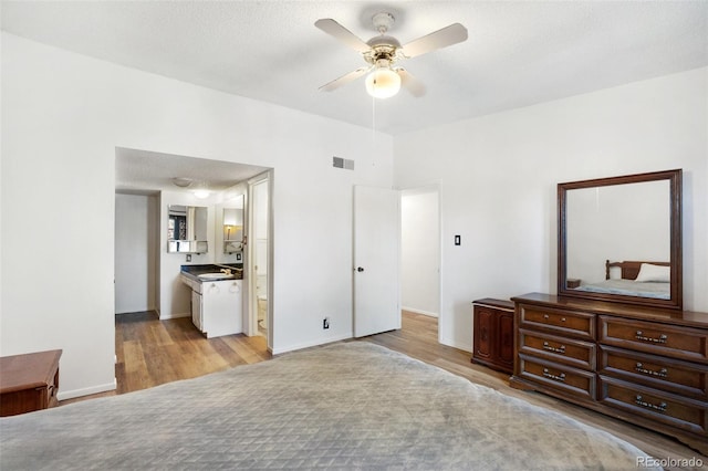 bedroom featuring ensuite bathroom, light hardwood / wood-style flooring, ceiling fan, and sink