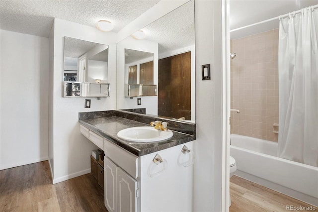 full bathroom with shower / bathtub combination with curtain, wood-type flooring, a textured ceiling, toilet, and vanity