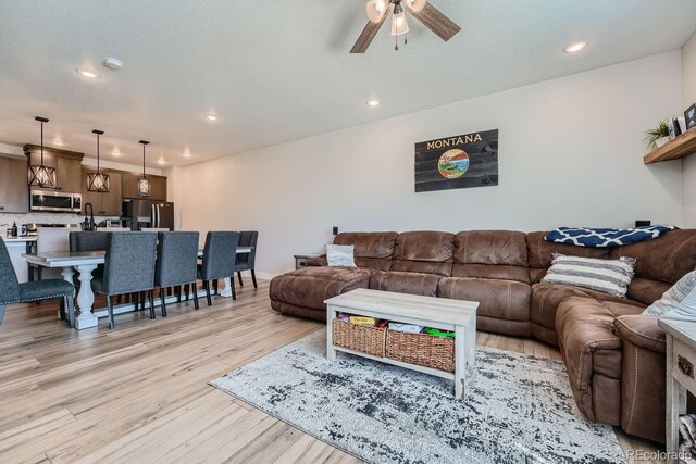16433 Askins Loop, Parker, CO 80134 - living area with light wood-style flooring, a ceiling fan, and recessed lighting