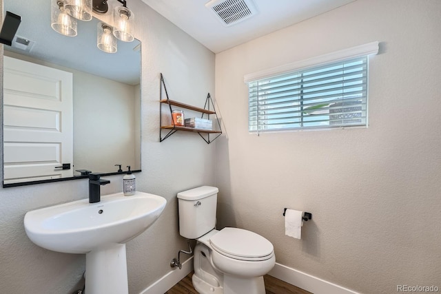 16433 Askins Loop, Parker, CO 80134 - bathroom with wood finished floors, toilet, baseboards, and a sink