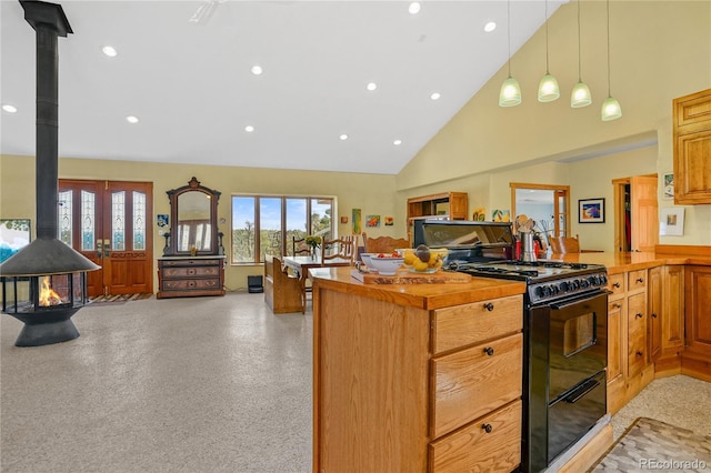 kitchen with a wood stove, high vaulted ceiling, black gas range, open floor plan, and recessed lighting