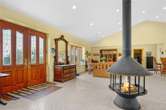 foyer with high vaulted ceiling, a wood stove, and recessed lighting