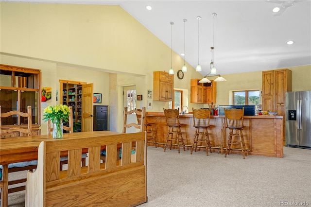 dining room featuring high vaulted ceiling, recessed lighting, and light colored carpet