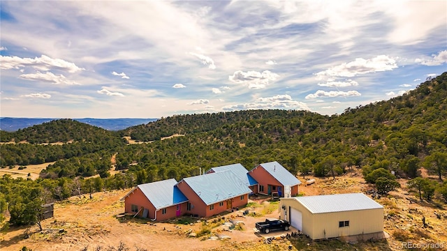 birds eye view of property featuring a view of trees and a mountain view