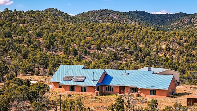 birds eye view of property featuring a view of trees and a mountain view