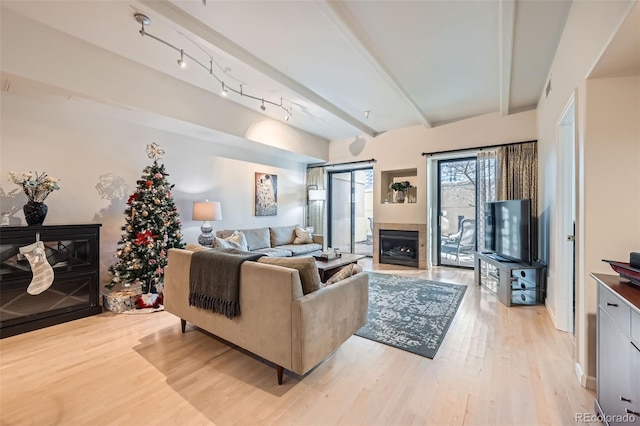 living room featuring beamed ceiling, light wood-type flooring, and track lighting