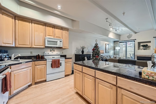 kitchen featuring beamed ceiling, light wood-type flooring, white appliances, and light brown cabinetry