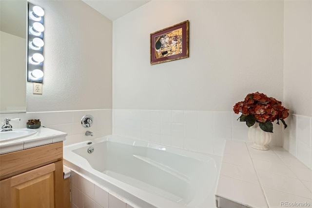 bathroom featuring vanity and tiled tub