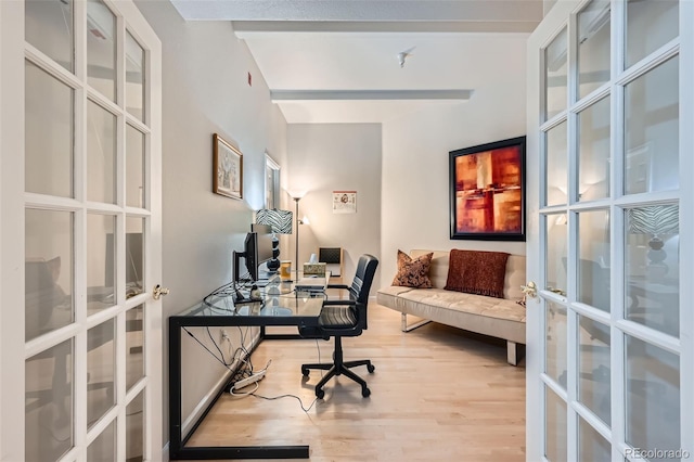 office area with light hardwood / wood-style floors and french doors