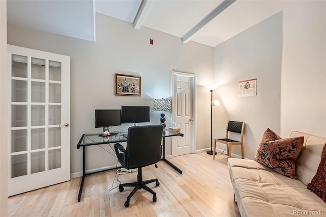 home office with beamed ceiling and light hardwood / wood-style floors