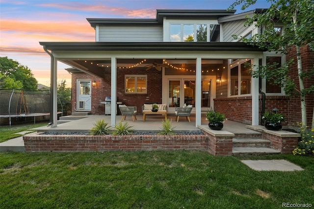 5528 S Jasper Way, Centennial, CO 80015 - back of house featuring a trampoline, outdoor lounge area, and brick siding