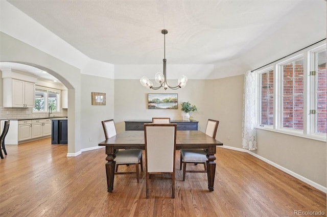 5528 S Jasper Way, Centennial, CO 80015 - dining area with a chandelier, light wood-style floors, and arched walkways