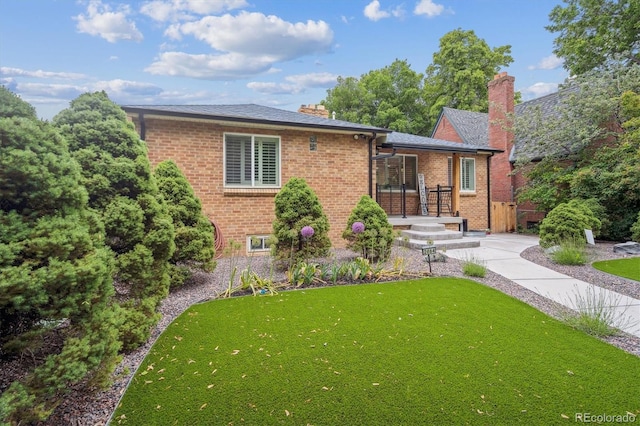 2664 Forest St, Denver, CO 80207 - view of front facade featuring a front lawn, brick siding, and a chimney