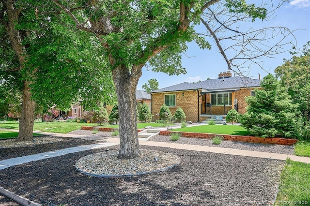 2664 Forest St, Denver, CO 80207 - view of front of property with a front yard, brick siding, and a chimney