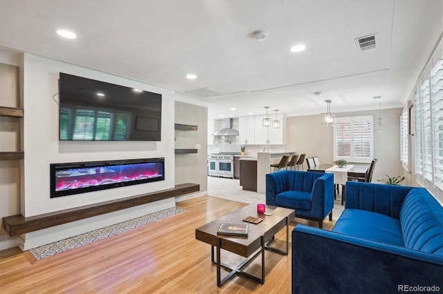 2664 Forest St, Denver, CO 80207 - living room featuring light wood-type flooring, a glass covered fireplace, and recessed lighting