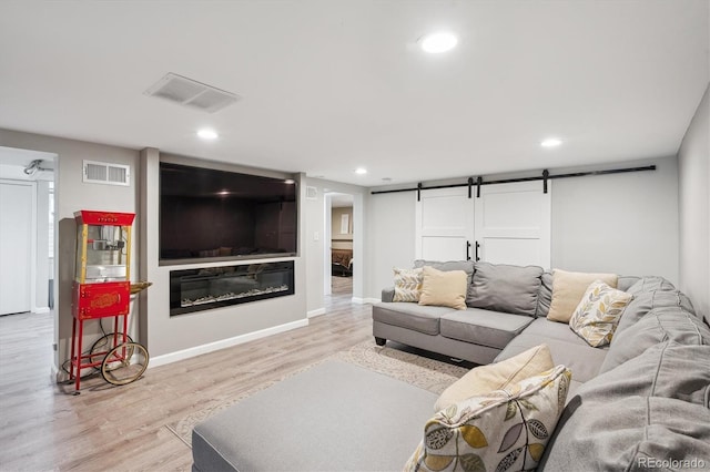 2664 Forest St, Denver, CO 80207 - living room with wood finished floors, a barn door, recessed lighting, a glass covered fireplace, and baseboards