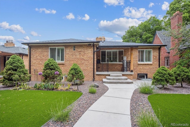 2664 Forest St, Denver, CO 80207 - view of front of house featuring brick siding, a front lawn, and a chimney