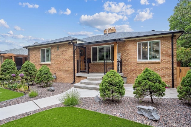 2664 Forest St, Denver, CO 80207 - view of front of house with brick siding, a chimney, covered porch, and a shingled roof