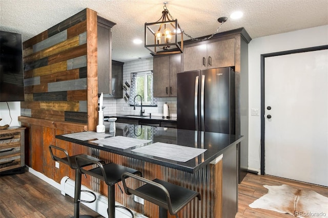 2700 S Holly St Unit 202, Denver, CO 80222 - kitchen with freestanding refrigerator, dark countertops, dark wood-style floors, tasteful backsplash, and a textured ceiling