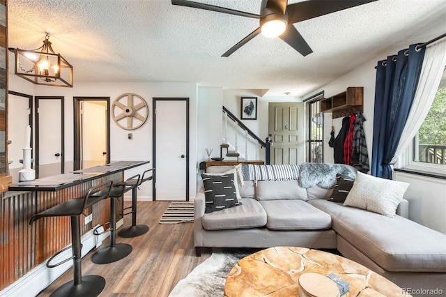 2700 S Holly St Unit 202, Denver, CO 80222 - living room with stairs, a textured ceiling, wood finished floors, a chandelier, and ceiling fan