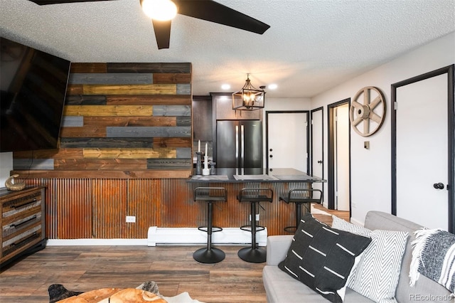 2700 S Holly St Unit 202, Denver, CO 80222 - indoor bar featuring freestanding refrigerator, wood finished floors, ceiling fan, a textured ceiling, and a chandelier