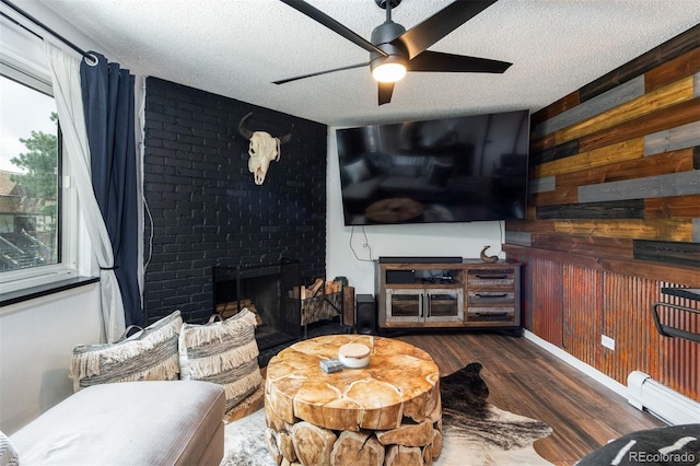 2700 S Holly St Unit 202, Denver, CO 80222 - living area featuring a textured ceiling, a brick fireplace, a ceiling fan, wood finished floors, and wooden walls