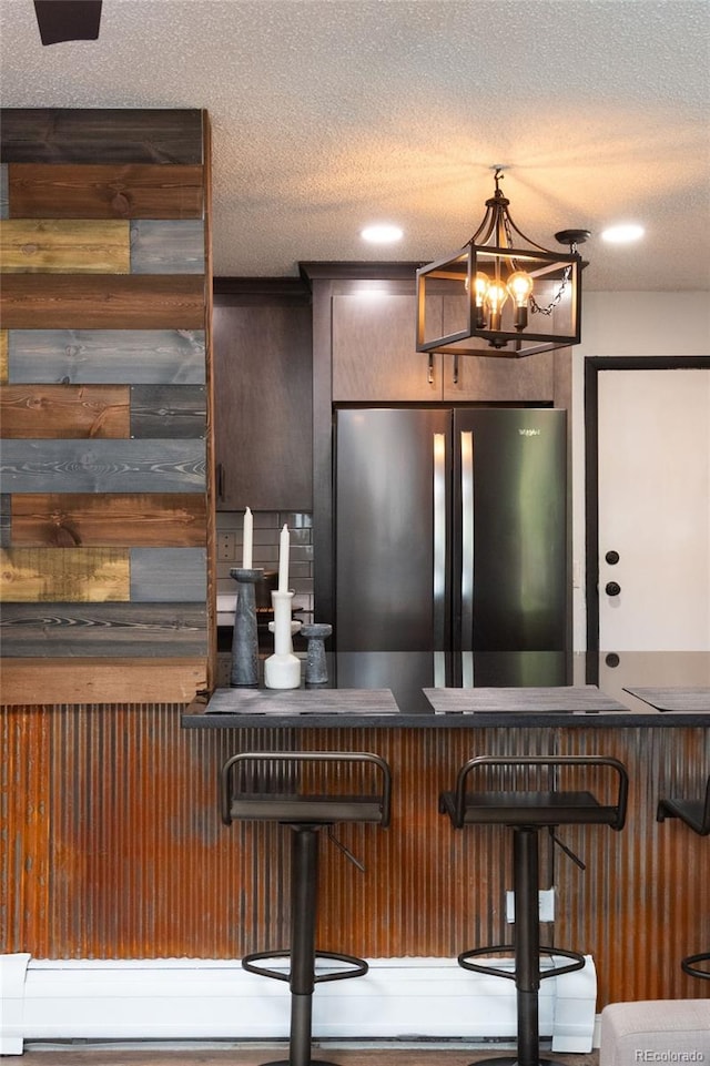 2700 S Holly St Unit 202, Denver, CO 80222 - bar area featuring freestanding refrigerator, a chandelier, and a textured ceiling