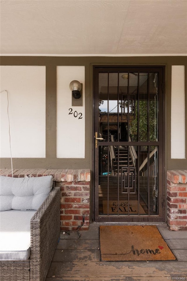 2700 S Holly St Unit 202, Denver, CO 80222 - doorway to property with covered porch and stucco siding