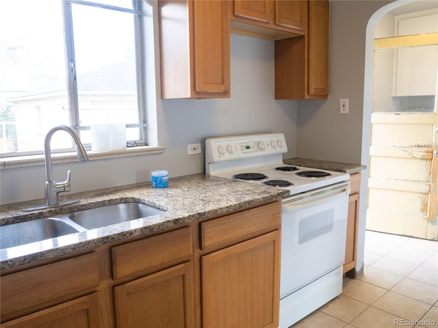 3820-3830 Pierce St, Wheat Ridge, CO 80033 - kitchen with white electric stove, light tile patterned floors, light stone countertops, and arched walkways