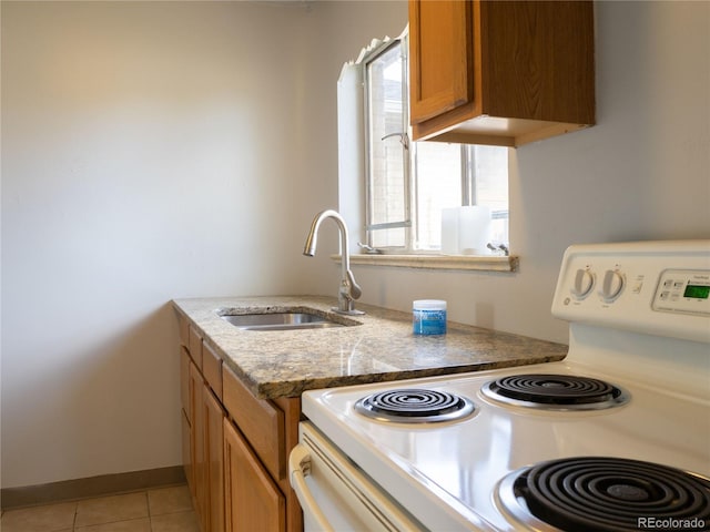 3820-3830 Pierce St, Wheat Ridge, CO 80033 - kitchen featuring white electric range oven, brown cabinets, light tile patterned floors, and light stone countertops