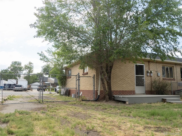 3820-3830 Pierce St, Wheat Ridge, CO 80033 - view of side of home with a gate, brick siding, and concrete driveway