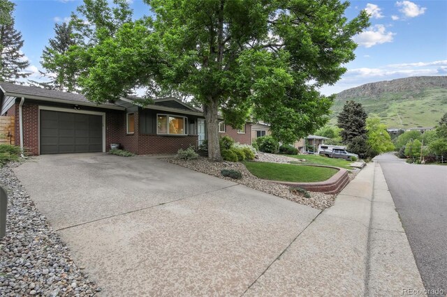 632 Wyoming St, Golden, CO 80403 - ranch-style house featuring driveway, an attached garage, brick siding, and a mountain view