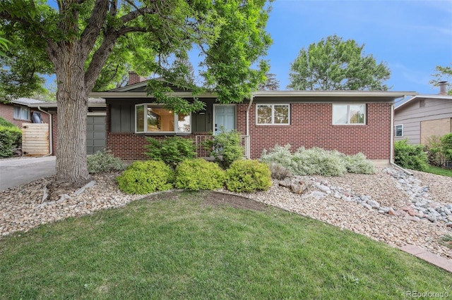 632 Wyoming St, Golden, CO 80403 - view of front of house featuring brick siding, a front yard, an attached garage, and a chimney