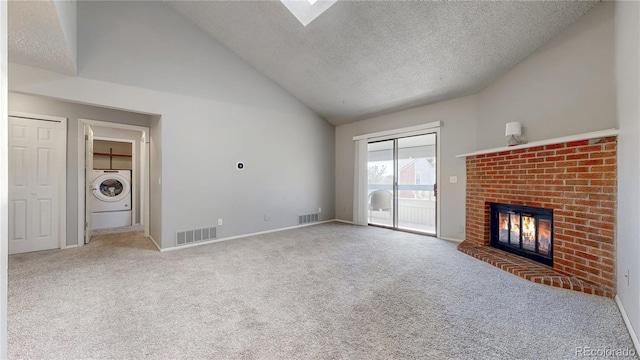 unfurnished living room featuring visible vents, carpet floors, washer / clothes dryer, a fireplace, and a textured ceiling