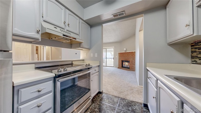 kitchen with visible vents, stainless steel appliances, light countertops, under cabinet range hood, and dark colored carpet