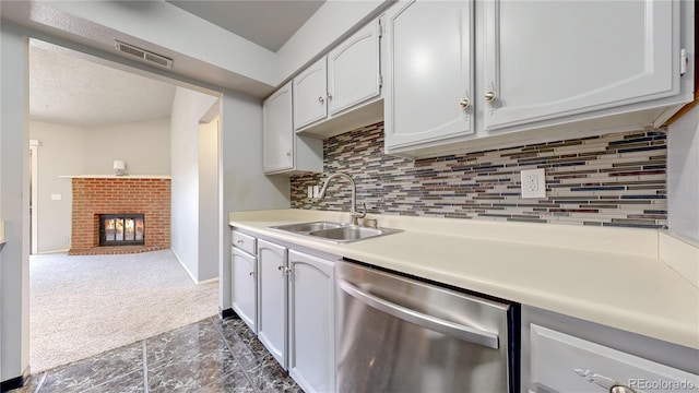 kitchen featuring visible vents, a sink, decorative backsplash, dishwasher, and dark colored carpet