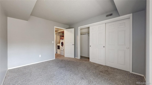 unfurnished bedroom with visible vents, baseboards, carpet, washer / dryer, and a closet