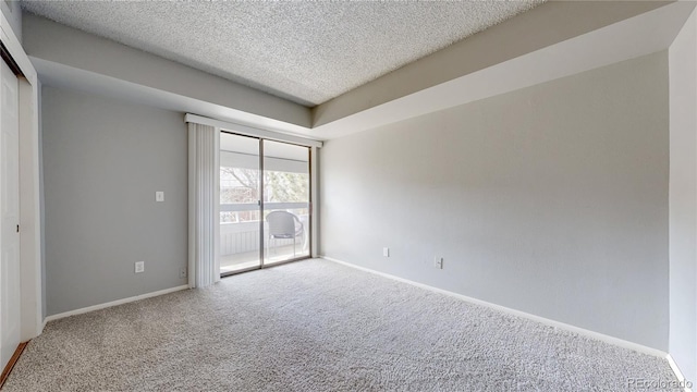 carpeted empty room with baseboards and a textured ceiling