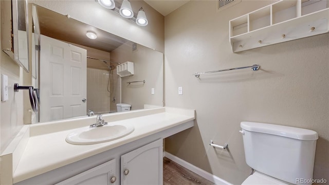 full bath featuring vanity, visible vents, baseboards, a shower, and toilet