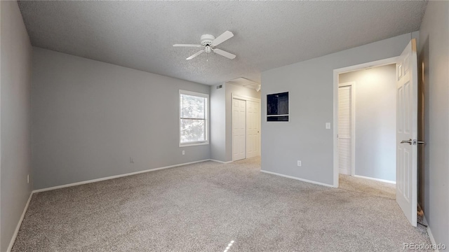 unfurnished bedroom with ceiling fan, baseboards, carpet flooring, a closet, and a textured ceiling