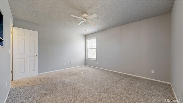 empty room with carpet flooring, a ceiling fan, baseboards, and a textured ceiling