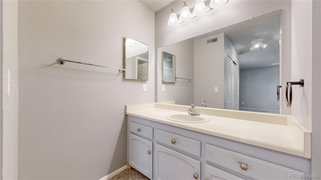 bathroom featuring vanity, baseboards, and visible vents