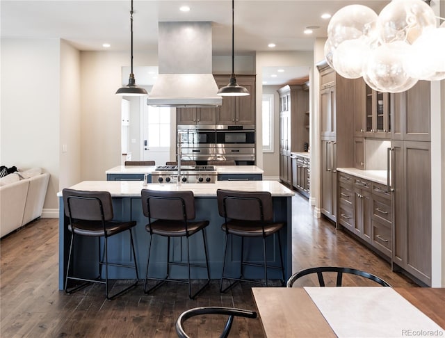 295 Jersey St, Denver, CO 80220 - kitchen featuring dark wood-style flooring, a kitchen island with sink, light countertops, a kitchen bar, and custom exhaust hood
