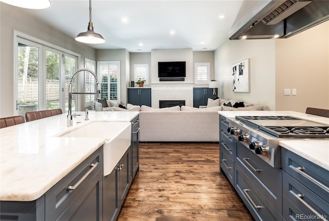 295 Jersey St, Denver, CO 80220 - kitchen with dark wood-style flooring, stainless steel gas cooktop, a healthy amount of sunlight, wall chimney range hood, and a sink