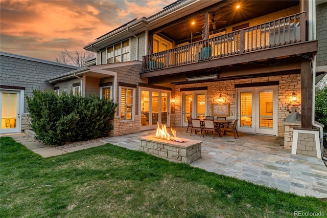 295 Jersey St, Denver, CO 80220 - back of house at dusk with a patio, a yard, an outdoor fire pit, and a balcony
