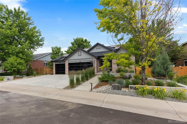 9161 W Lake Dr, Littleton, CO 80123 - view of front of property featuring brick siding, a garage, concrete driveway, and solar panels