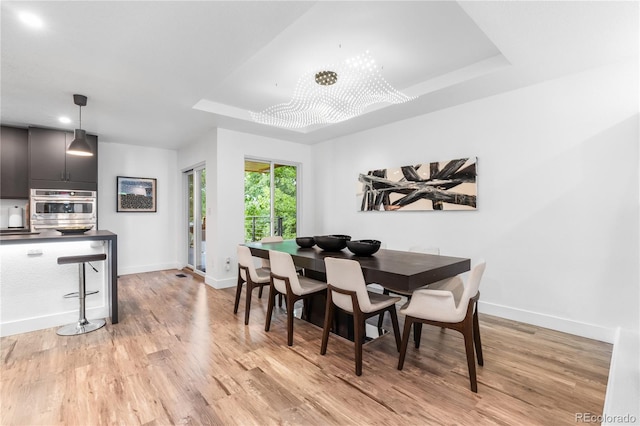 9161 W Lake Dr, Littleton, CO 80123 - dining room with a tray ceiling and light wood-style flooring